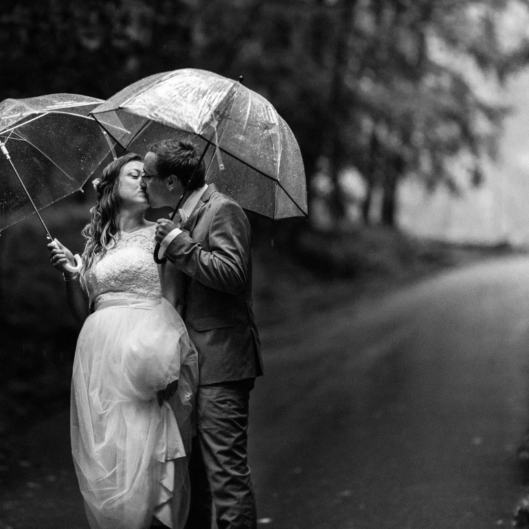 Svatební fotografie v lese, ženich a nevěsta v dešti